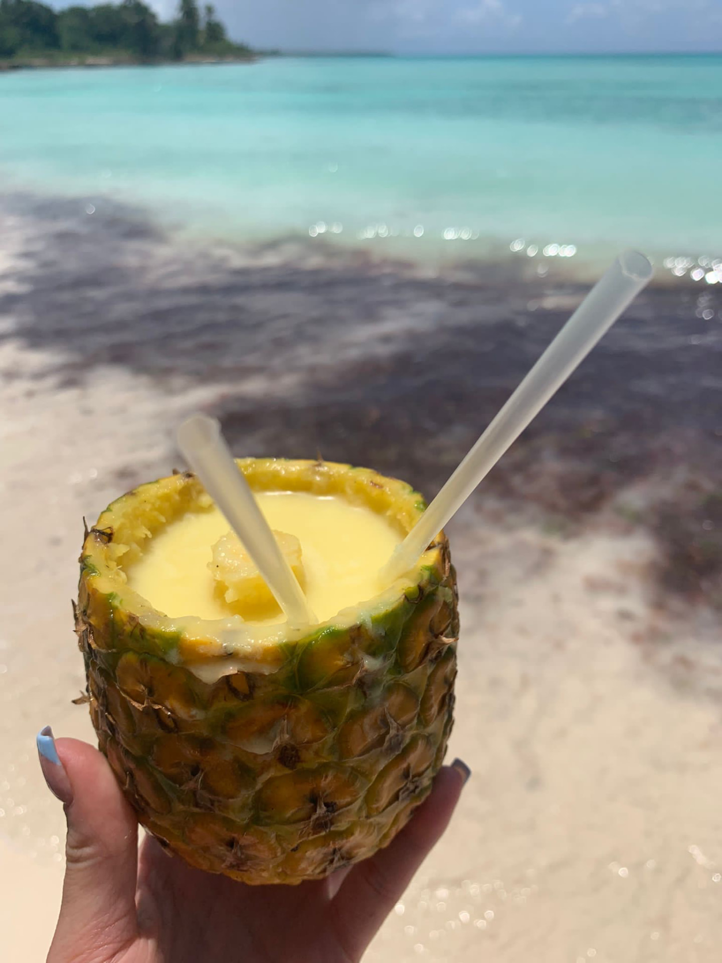 Boisson servie dans un ananas face à une plage
