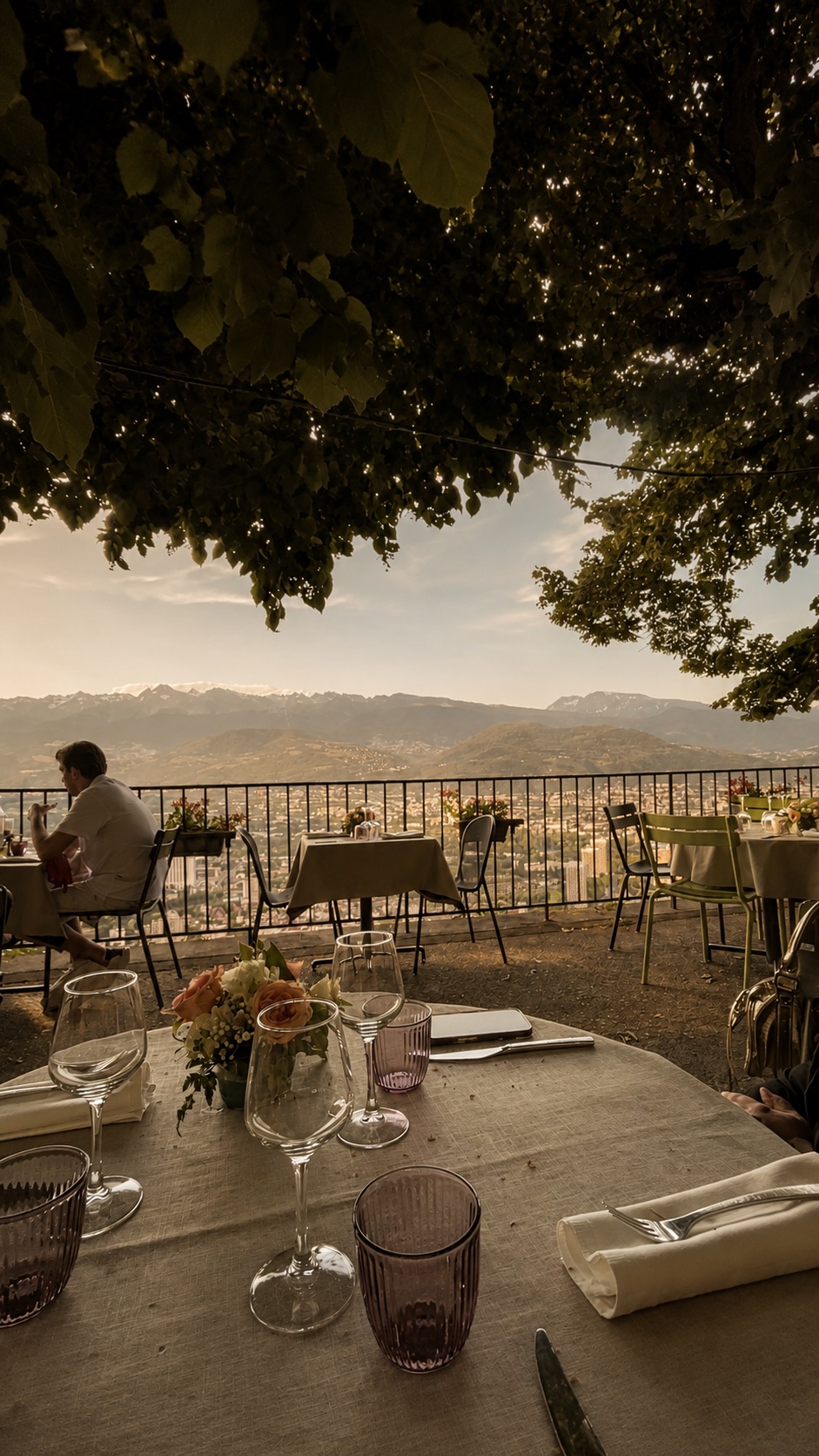 Table dressée en terrasse face aux montagnes au coucher du soleil